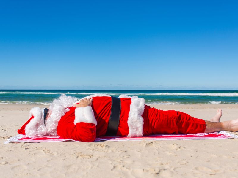 pere noel faisant une sieste sur la plage en australie / visiondeco